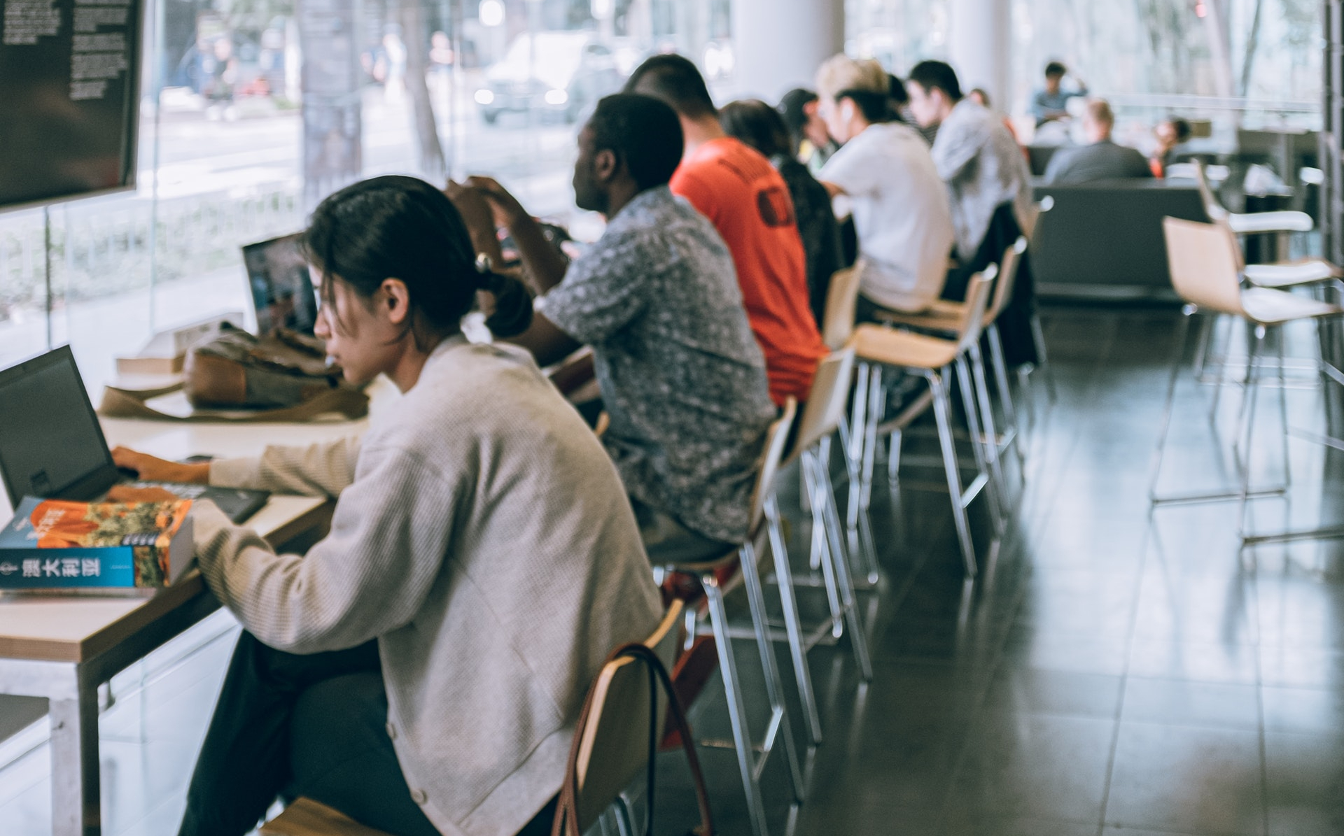 A row of people using laptops in a building